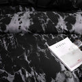 Close-up texture of marble print on bedding set with book and throw