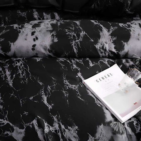 Close-up texture of marble print on bedding set with book and throw