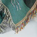 Detailed view of fringed edge on ocean-themed tapestry blanket