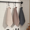 Set of towels hanging on black rack in bathroom