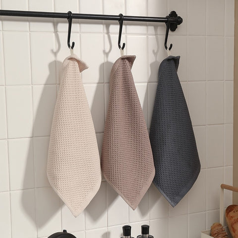 Set of towels hanging on black rack in bathroom
