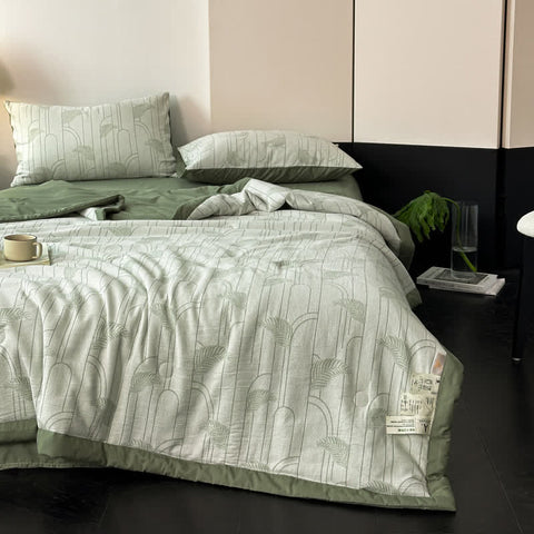 Minimalist bedroom with soft green cotton quilt and two matching pillows