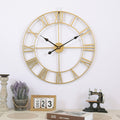 Gold wall clock with Roman numerals on a white wall, surrounded by decorative items.