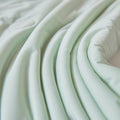 Smooth folds and soft texture of mint green ice silk quilt fabric showing breathable comfort