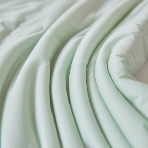 Smooth folds and soft texture of mint green ice silk quilt fabric showing breathable comfort