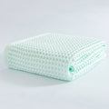 Mint green waffle bath towel folded neatly on display