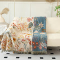 Reversible floral throw blanket draped on sofa with contrast pattern