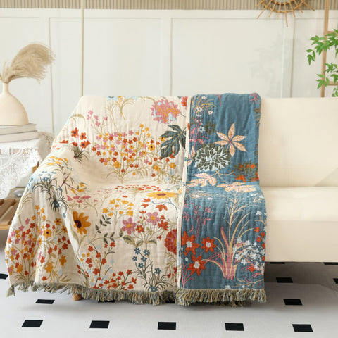 Reversible floral throw blanket draped on sofa with contrast pattern