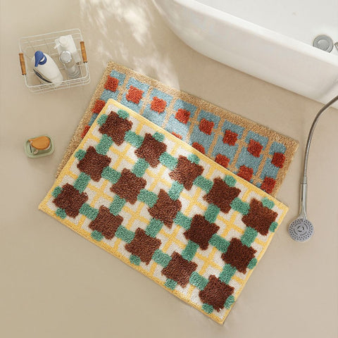 Set of two Moroccan bath mats with bold patterns next to shower