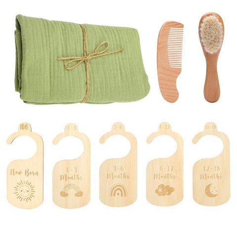 Baby care set with green cloth, comb, brush, and wooden height charts on a white background