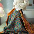 Nehari boho cotton blanket in blue and orange pattern, draped over a bed with woman holding it, vibrant and lightweight for summer use
