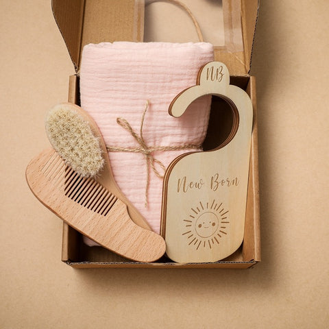 Newborn towel gift set in neutral tones with brush, comb, and wooden markers