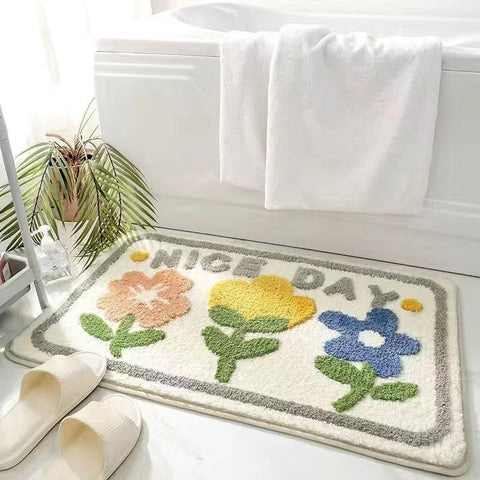 Cheerful white bath mat with colorful flowers and “NICE DAY” text, perfect for brightening up any bathroom space.