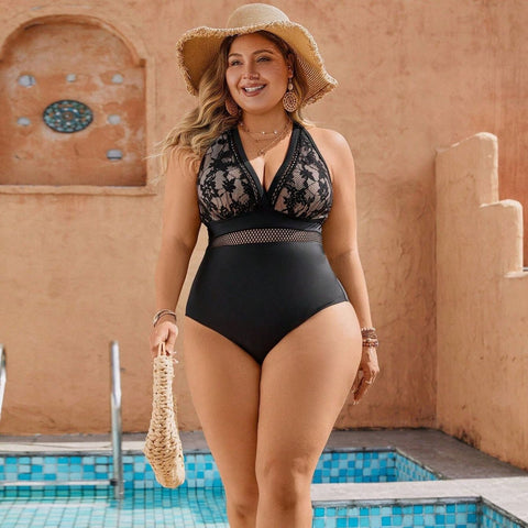 Plus-size model wearing the Noir Lace One-Piece Swimsuit poolside with straw hat
