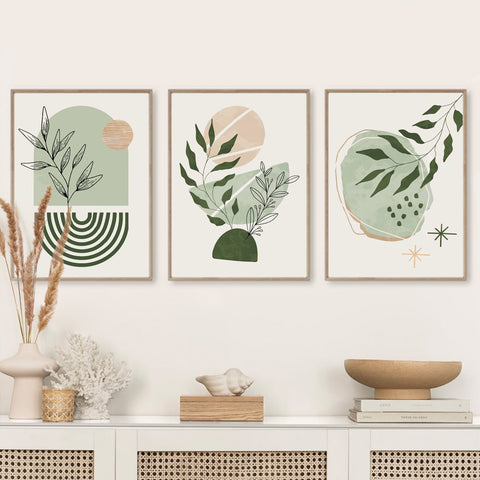 Three framed botanical prints on a wall above a cabinet with decorative items.
