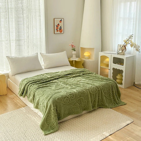 Olive green butterfly fleece blanket styled over modern low bed with natural light

