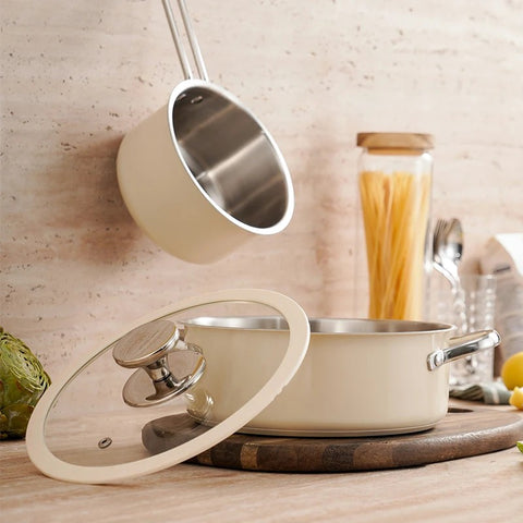 Open cream saucepan with glass lid on wooden countertop