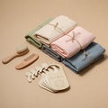Five baby towel gift sets in assorted pastel colors with wooden accessories
