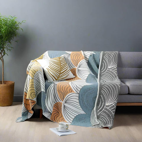 Pastel elegance cotton quilt draped over modern sofa with scallop pattern in peach, mint, and beige colors