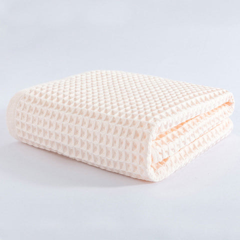 Folded peach waffle towel with breathable cotton texture
