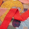 Close-up of Persimmon Bloom cotton blanket red border and colorful floral pattern texture