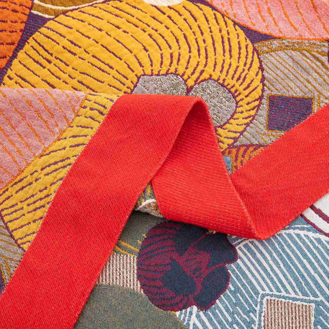 Close-up of Persimmon Bloom cotton blanket red border and colorful floral pattern texture