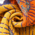 Close-up of soft cotton fabric texture in mustard yellow and burnt orange tones, showing detailed weaving of Persimmon Bloom pillowcases.