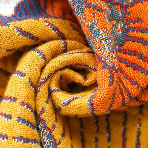 Close-up of soft cotton fabric texture in mustard yellow and burnt orange tones, showing detailed weaving of Persimmon Bloom pillowcases.