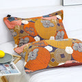 Persimmon Bloom cotton pillowcases featuring vibrant orange, pink, and gray floral and persimmon designs, displayed on a white bed next to a wooden tray with a plate and lemon.