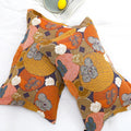 Top view of Persimmon Bloom cotton pillowcases showcasing bright orange, yellow, and gray persimmon and floral patterns on white bedding.