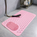 Pink shower mat with textured foot scrubber laid flat next to shower

