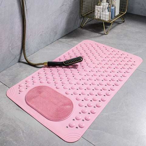 Pink shower mat with textured foot scrubber laid flat next to shower

