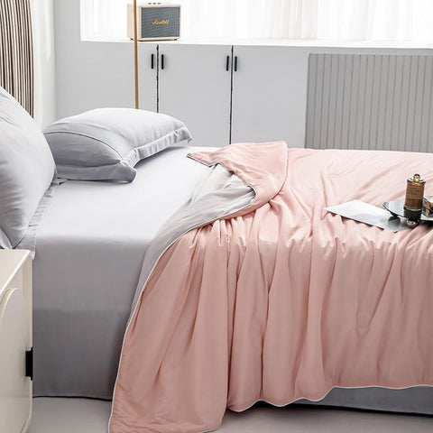 Light pink and gray double-layered ice silk quilt spread on modern bed with soft pillows