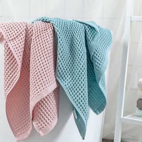 Pink and teal waffle bath towels hanging neatly side by side