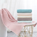 Pink and teal waffle bath towels hanging neatly side by side