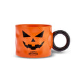 Orange mug with black pumpkin face design on a white background