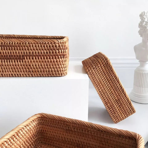 Set of rattan baskets on white shelf with art frame