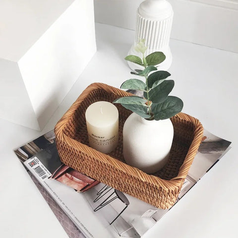 Wicker basket with a candle and small plant on a magazine