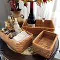 Woven baskets with various items including a bottle of wine on a table.