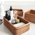 Rattan storage basket with toiletries and towel on bathroom counter