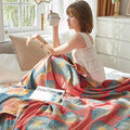 Relaxing with a cup on bed with red dandelion reversible quilt – organic cotton bedding