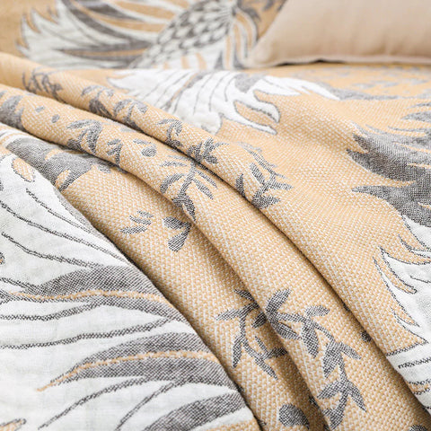 Fabric detail of reversible beige cotton jacquard blanket with tassels