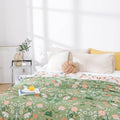 Bed with floral patterned comforter in a bright bedroom