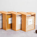 Rice and pasta labeled bamboo storage on cement floor
