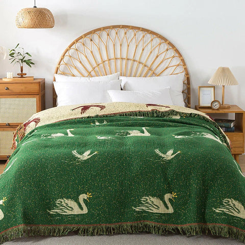 Royal Goose reversible cotton tassel blanket on bed in natural rattan bedroom