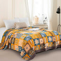 Sahara Patchwork Cotton Blanket with vibrant tribal patterns on a cozy bed setting