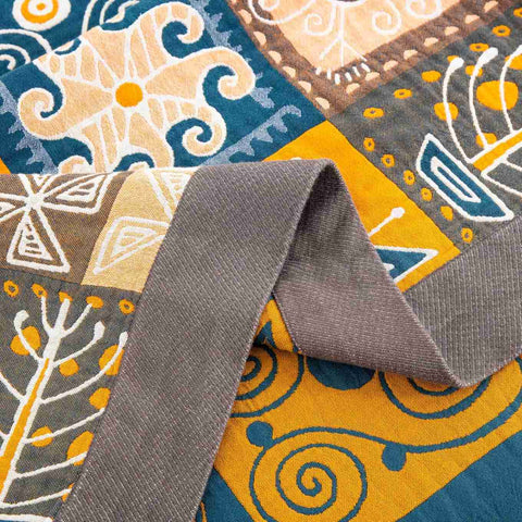 Close-up of Sahara Patchwork Cotton Throw fabric showing vibrant tribal pattern and detailed textured stitching