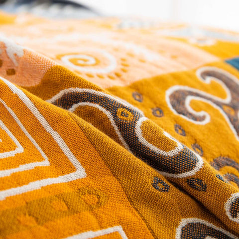 Close-up of Sahara Patchwork Cotton Throw fabric showing rich texture and vibrant tribal pattern details