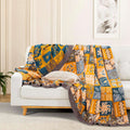  Sahara Patchwork Cotton Throw draped over white sofa with decorative pillow, showcasing vibrant tribal patterns and cozy texture