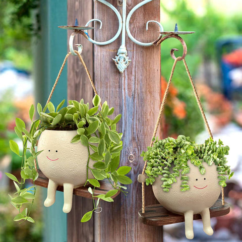  Pair of smiley hanging planters with lush greenery